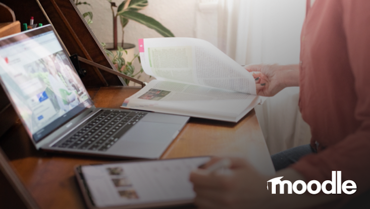 Frau vor Laptop und Lehrbuch