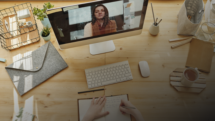 Schreibtisch mit Monitor und Notizbuch