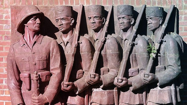 Fünf in Bronze eingelassene Soldaten an einer Backsteinmauer.