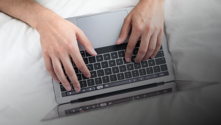 Mann tippt auf Laptop