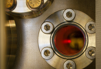 Eine Wolke ultrakalter Atome leuchtet in einer Vakuumkammer 