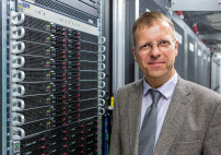 RRZ-Direktor Prof. Dr.-Ing. Stephan Olbrich vor dem neuen Höchstleistungsrechner