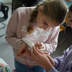 Zu sehen sind Schülerinnen, die eine Sonde bauen.