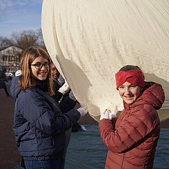 Schülerinnen die den Ballon mit Helium füllen.